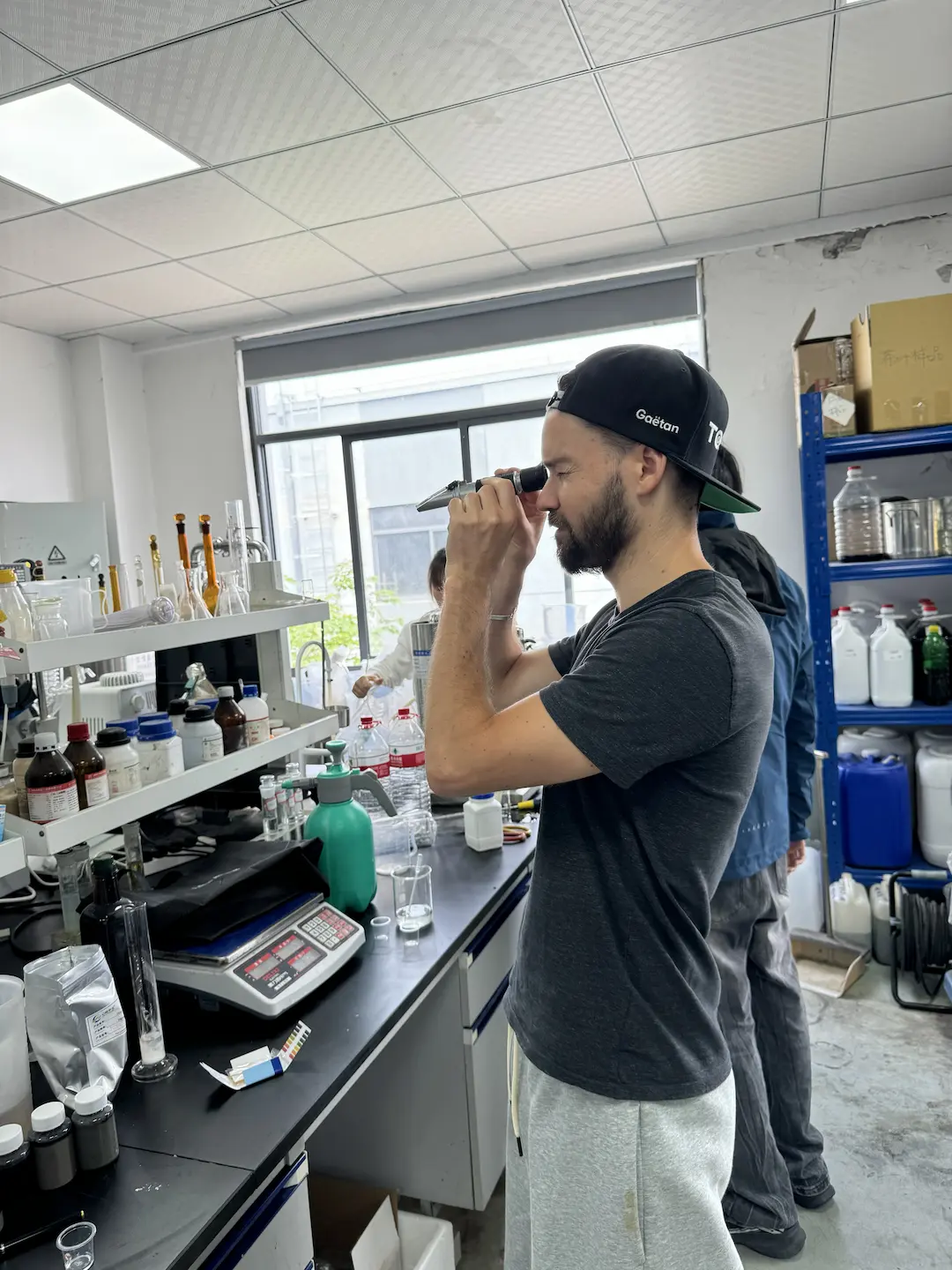 Gaëtan measuring Brix levels in coconut water with a refractometer in a Chinese lab