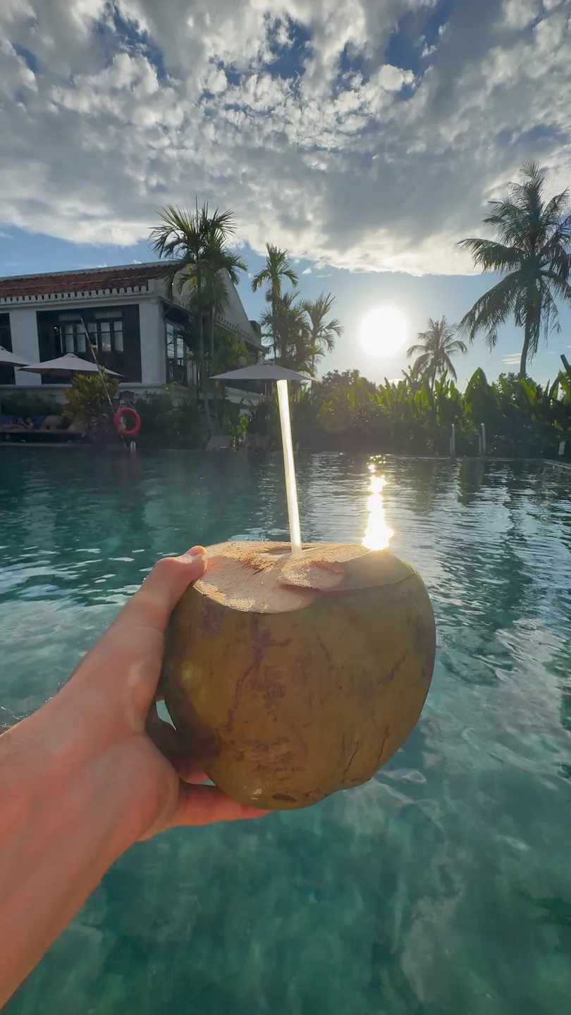 A coconut at an open-air coastal restaurant with a sea view