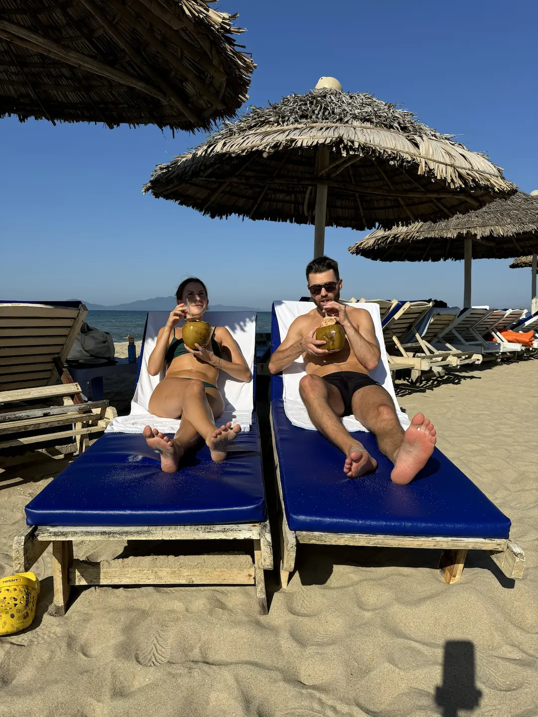 An empty lounger with a fresh coconut on Cửa Đại beach in the mid-morning light